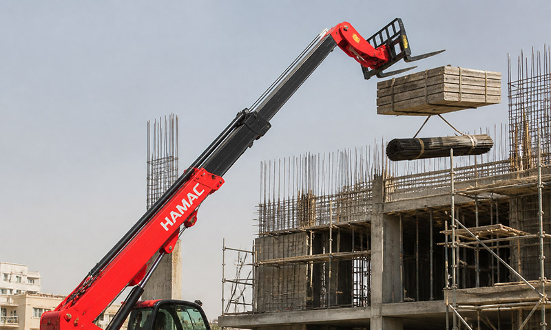HAMAC HT3510 telehandler positioning steel beams and roof sheets at height around a warehouse steel frame on an African industrial construction site.